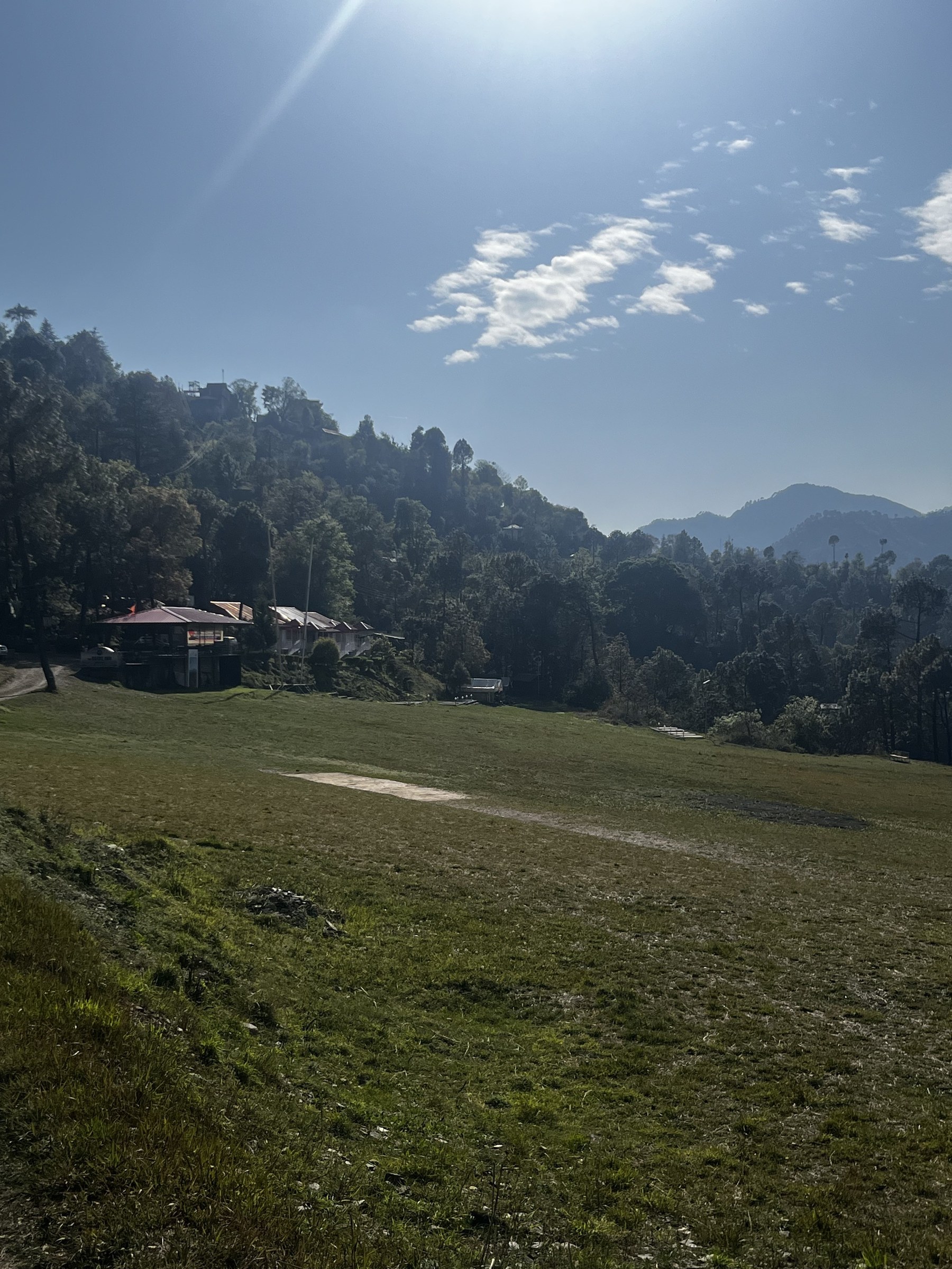 Wide view of the open paragliding field with resort buildings on the left at The Glide Inn