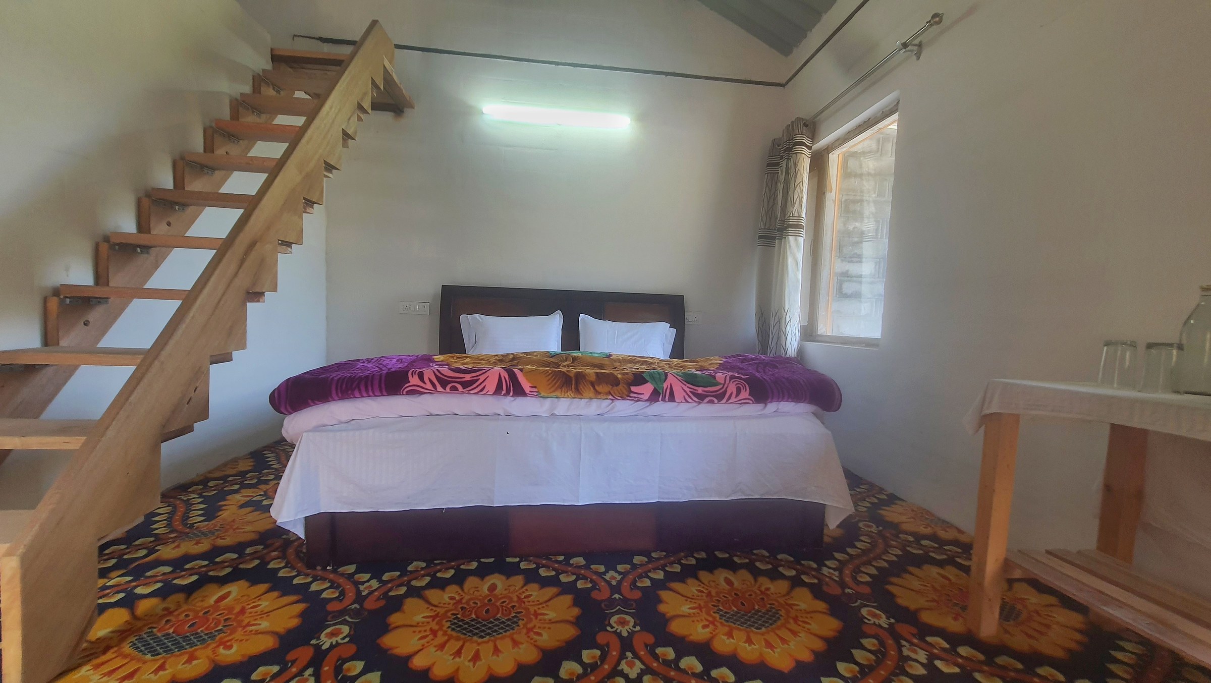 Cottage room interior with double bed wooden staircase and window at The Glide Inn Shimla