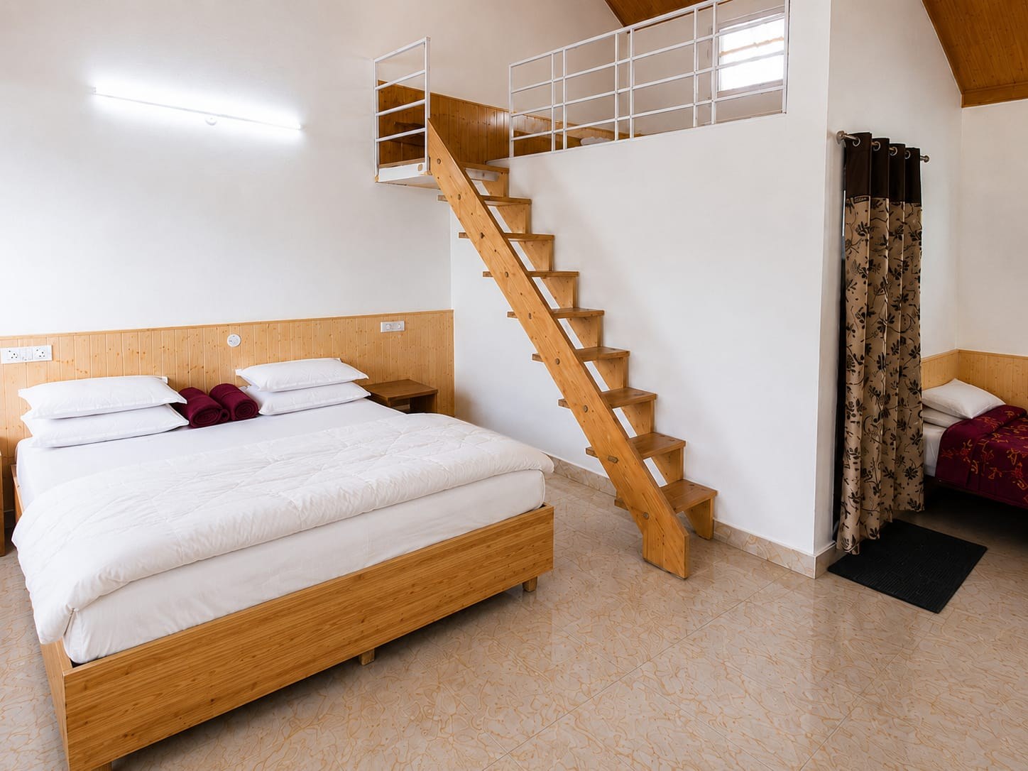 Cottage twin-sharing room with double bed, single bed and wooden loft staircase at The Glide Inn Shimla