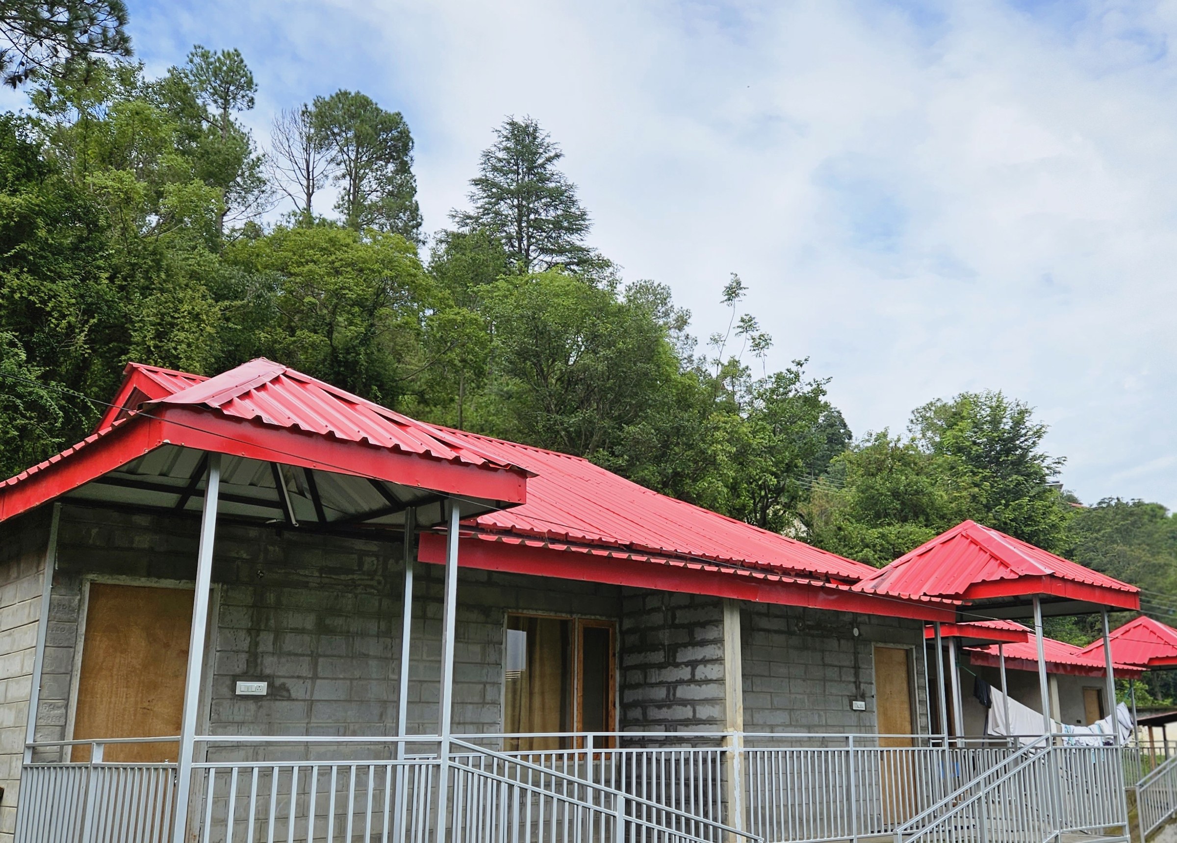 The Glide Inn cottages building with stone walls and red roof surrounded by pine trees