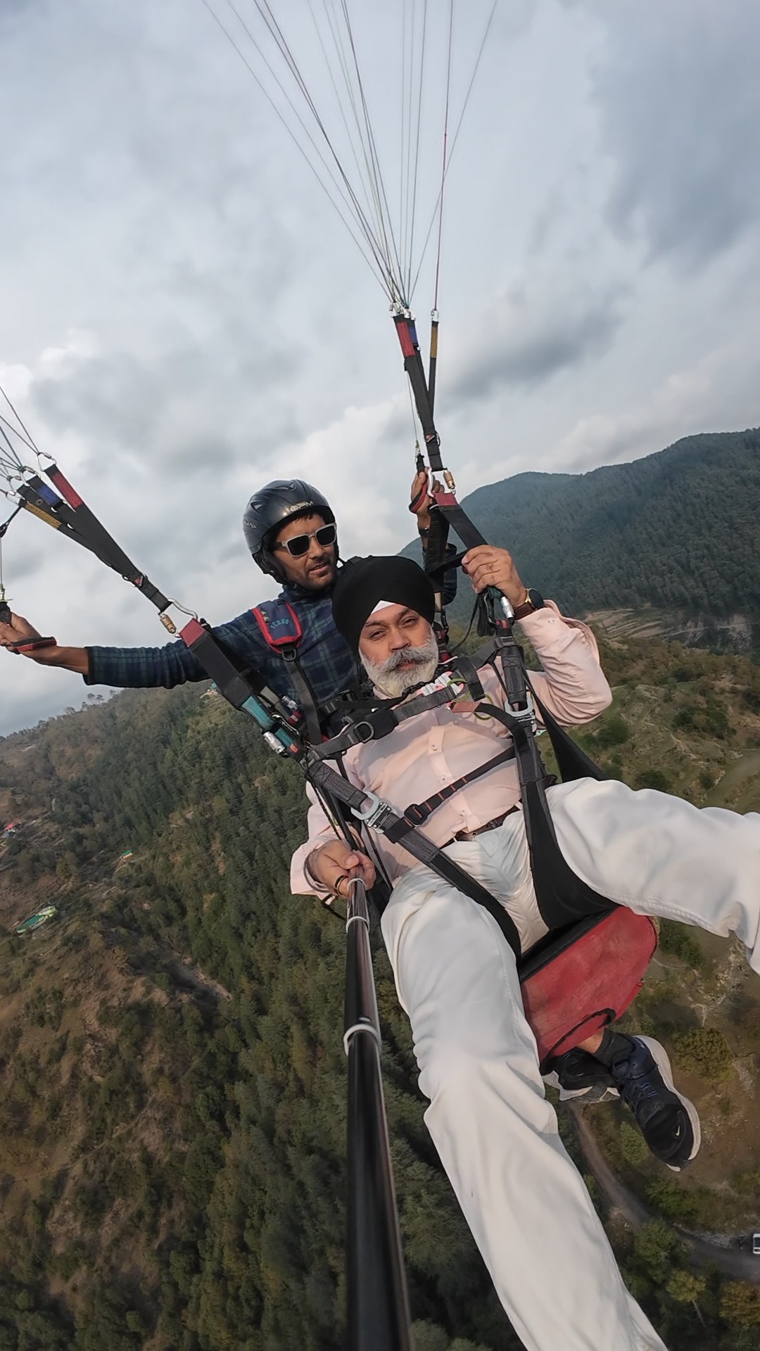 Happy guest enjoying a tandem paragliding flight over the Himalayan hills near Shimla