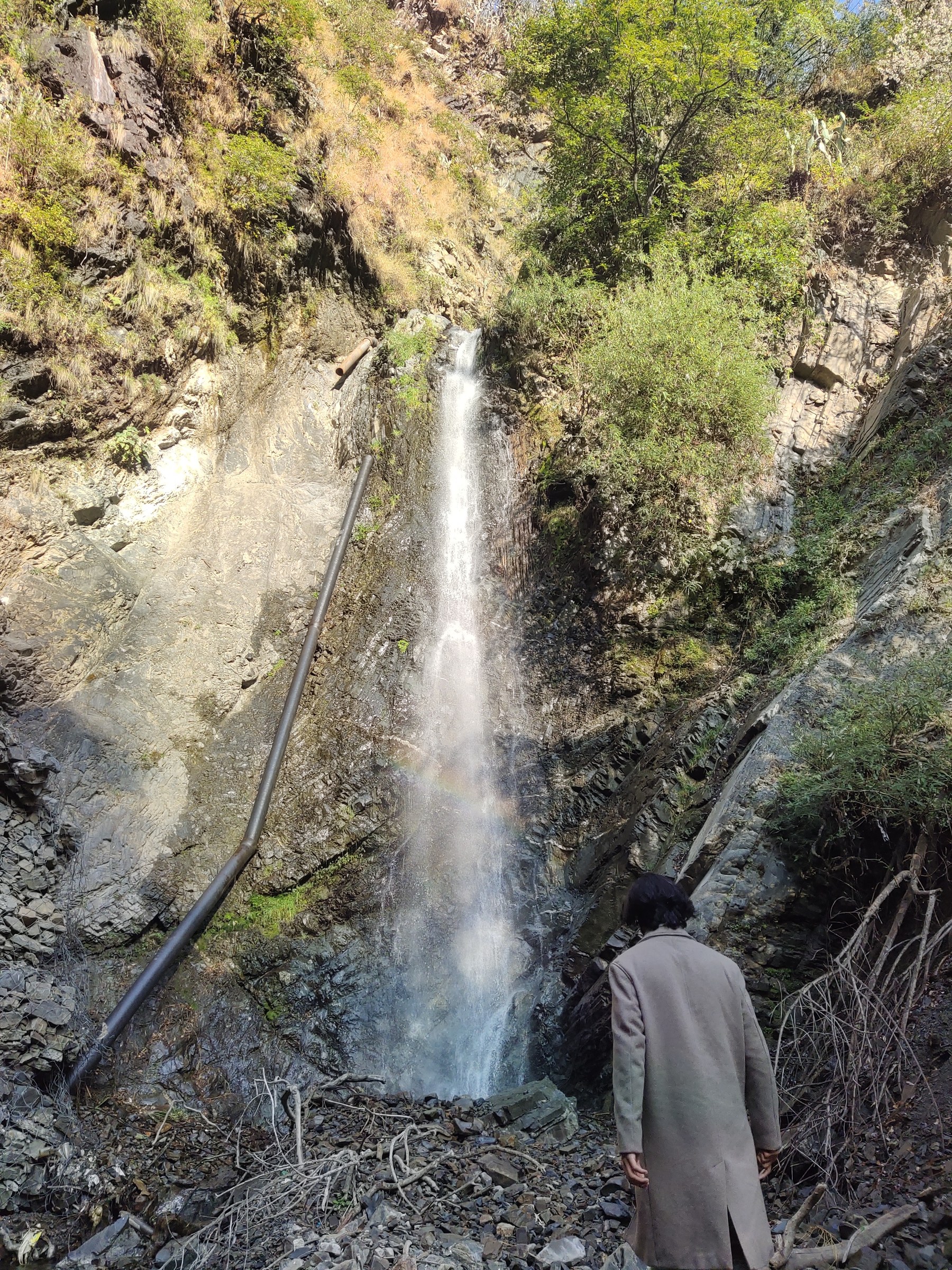 Close-up view of the hidden waterfall cascading down rocky terrain near The Glide Inn